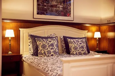 a bedroom with a white bed with two lamps at Realeneiland Bed & Breakfast in Amsterdam