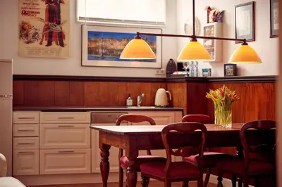 a kitchen with a table with red chairs and yellow lights at Realeneiland Bed & Breakfast in Amsterdam