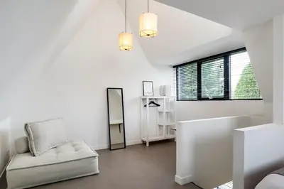 a white living room with a couch and a window at The Slow in Zuidoostbeemster