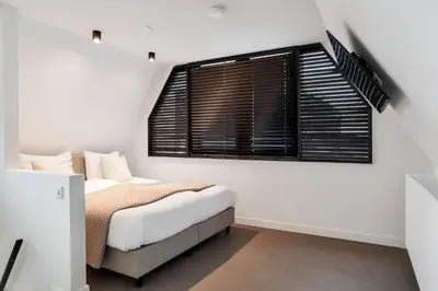 a bedroom with a bed and a window at The Slow in Zuidoostbeemster