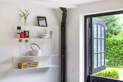 a room with white shelves and a window at The Slow in Zuidoostbeemster