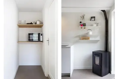 a hallway with white walls and white shelves and a television at The Slow in Zuidoostbeemster