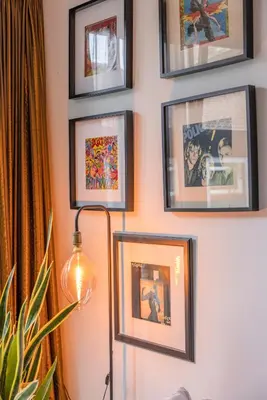 a group of pictures on a wall with a lamp at Passage - Spacious Suite in Historic Centre in Haarlem