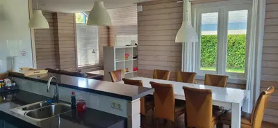 a kitchen with a sink and a table and chairs at The Blue House - Luxurious Waterfront Villa Zeewolde in Zeewolde