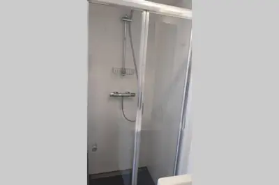 a bathroom with a shower with a glass door at bij San & Ka in Hauwert