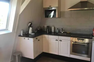 a kitchen with a sink and a stove at bij San & Ka in Hauwert