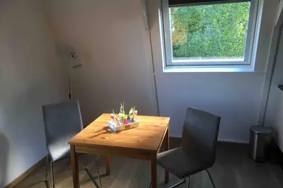 a dining room table with two chairs and a window at bij San & Ka in Hauwert