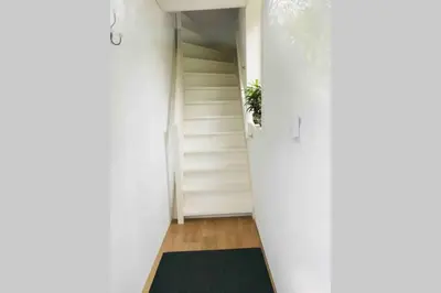 a hallway with white walls and a green rug at bij San & Ka in Hauwert