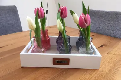 three vases filled with pink and white flowers in a box at bij San & Ka in Hauwert