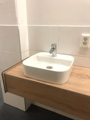 a white sink on a wooden counter in a bathroom at Outside Inn in Amsterdam