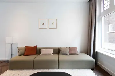 a couch in a living room with a window at Anegang Boutique Appartement in Haarlem