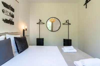 a bedroom with a large white bed with a mirror at Utrecht City Apartments - Maliesingel in Utrecht