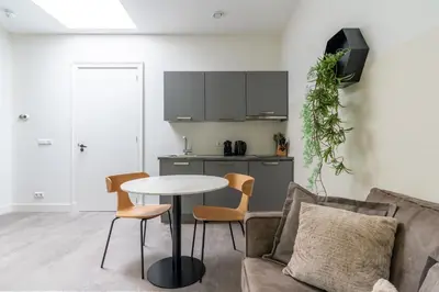 a living room with a table and chairs and a kitchen at Utrecht City Apartments - Maliesingel in Utrecht