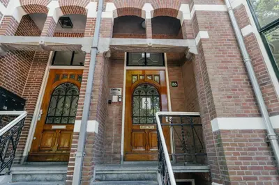 two wooden doors on a brick building with stairs at Utrecht City Apartments - Maliesingel in Utrecht