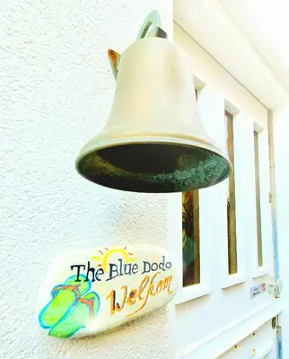 a bell hanging on the side of a building at The Blue Dodo in Zandvoort