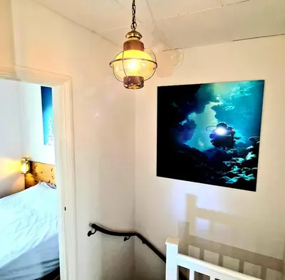 a bedroom with a tv on the wall and a bed at The Blue Dodo in Zandvoort
