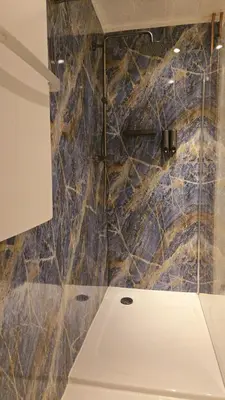 a bathroom with a stone wall and a toilet at The Blue Dodo in Zandvoort