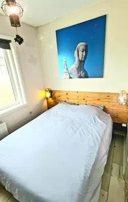 a bedroom with a bed with a statue on the wall at The Blue Dodo in Zandvoort