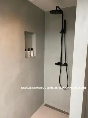 a bathroom with a shower in the corner of a room at Long Beach Rooms Zandvoort in Zandvoort