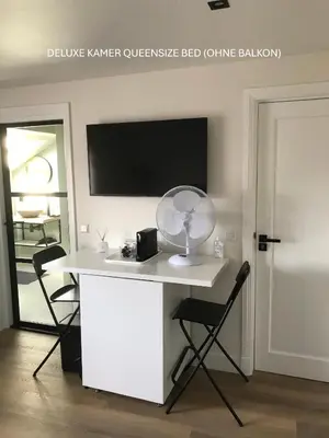 a white desk with a fan and two chairs at Long Beach Rooms Zandvoort in Zandvoort