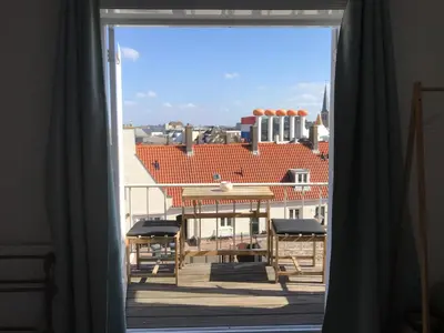 a window with a view of a building at Long Beach Rooms Zandvoort in Zandvoort