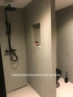 a corner of a room with a wall with a shelf at Long Beach Rooms Zandvoort in Zandvoort