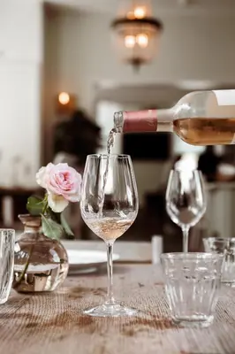 a person pouring wine into a glass on a table at Boutique Hotel - de Stadsherberg Alphen in Alphen aan den Rijn