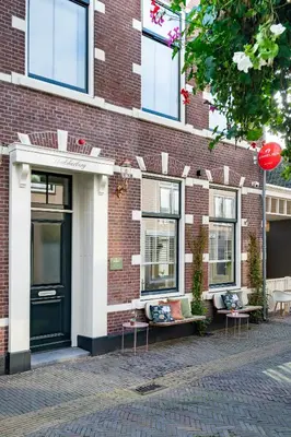a brick building with windows and benches on a street at Boutique Hotel - de Stadsherberg Alphen in Alphen aan den Rijn