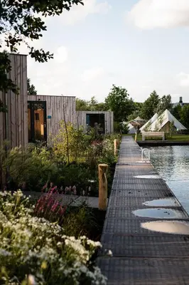 a wooden walkway next to a body of water at Zwier, de Vrijhaven in Vinkeveen