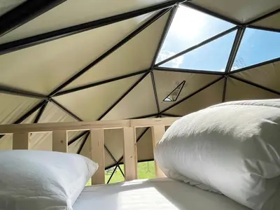 a bed in a tent with a large window at Camping de Vliert in Bunnik