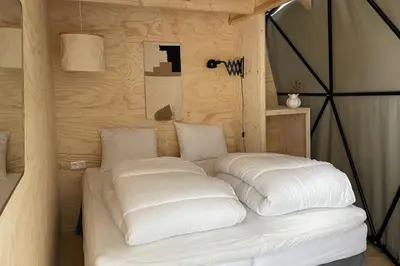 a bed with white pillows in a room at Camping de Vliert in Bunnik