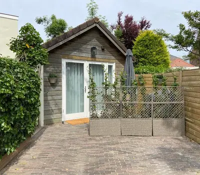 a small house with a gate and a fence at Het Krabbehuisje in Zandvoort