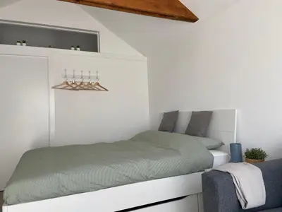 a bed in a white room with at Het Krabbehuisje in Zandvoort