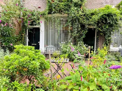 a garden with flowers and plants in front of a building at Marijke's guestroom in Amsterdam