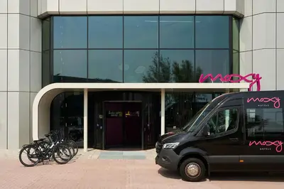 a black van parked in front of a building with bikes at Moxy Amsterdam Schiphol Airport in Hoofddorp