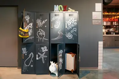 a group of refrigerator stalls with drawings on them at Moxy Amsterdam Schiphol Airport in Hoofddorp
