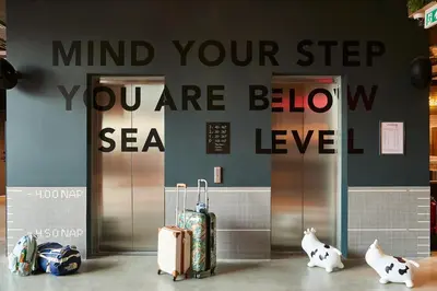a group of luggage sitting in front of an elevator at Moxy Amsterdam Schiphol Airport in Hoofddorp