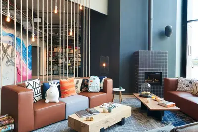 a living room with two couches and a table at Moxy Amsterdam Schiphol Airport in Hoofddorp