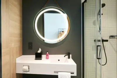 a bathroom with a white sink and a mirror at Moxy Amsterdam Schiphol Airport in Hoofddorp