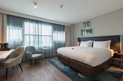 a hotel room with a bed and a desk and chairs at Crowne Plaza Utrecht - Central Station by IHG in Utrecht