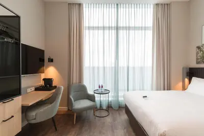 a hotel room with a bed and a desk and a television at Crowne Plaza Utrecht - Central Station by IHG in Utrecht