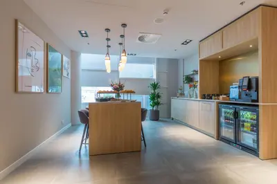 a kitchen with a bar and a counter with chairs at Crowne Plaza Utrecht - Central Station by IHG in Utrecht