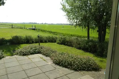 a view of a field from the window of a house at Accommodatie op boerderij Buitenlust in Weesp