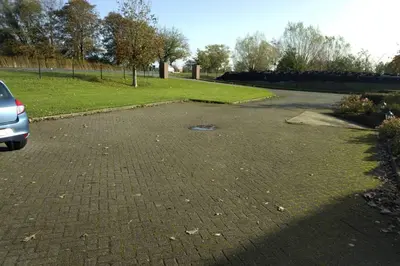 a parking lot with a car parked in a park at Accommodatie op boerderij Buitenlust in Weesp