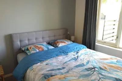 a bed with a blue comforter in a bedroom at Accommodatie op boerderij Buitenlust in Weesp