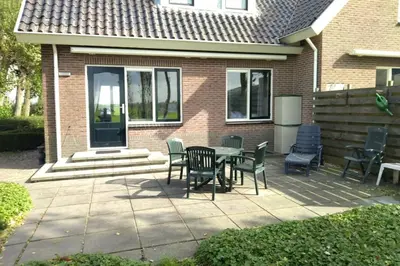 a patio with a table and chairs in front of a house at Accommodatie op boerderij Buitenlust in Weesp
