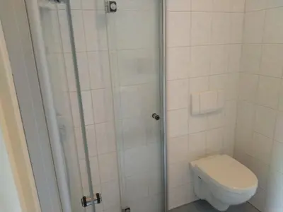a bathroom with a toilet and a glass shower at Accommodatie op boerderij Buitenlust in Weesp