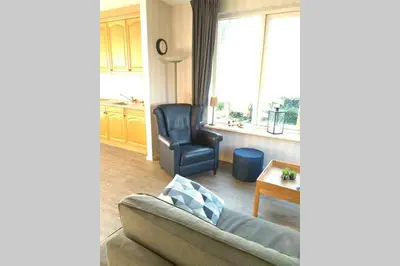 a living room with a couch and a chair at Accommodatie op boerderij Buitenlust in Weesp