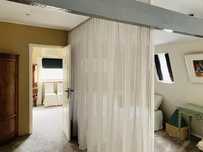 a room with a curtain that is open at Holiday home at the water, fire place, boat and SUP rent, near Amsterdam in Aalsmeer