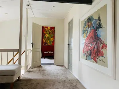 a hallway with a painting on the wall at Holiday home at the water, fire place, boat and SUP rent, near Amsterdam in Aalsmeer